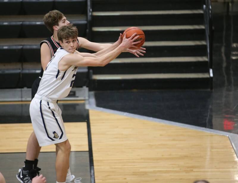 Marquette's Charlie Mullen saves the ball from going out of bounce as Woodland's Zandar Redke defends during the Tri-County Conference Tournament on Thursday, Jan. 25, 2024 at Putnam County High School.
