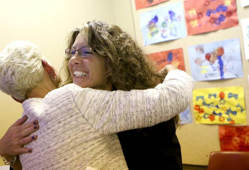 Newly named DeKalb High School Principal Michele Albano (right) hugs Jennie Hueber, DeKalb School District 428 director of curriculum and instruction, Tuesday after the District 428 board meeting in DeKalb.