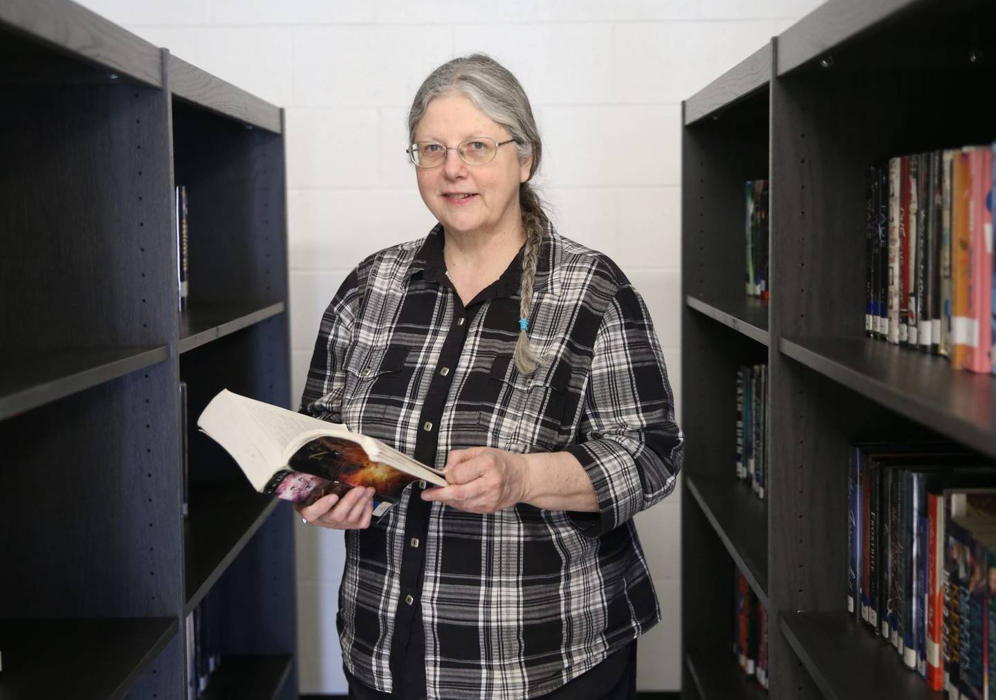 Annette Davis poses with a library book on Tuesday, March 28, 2023 at Putnam County High School.