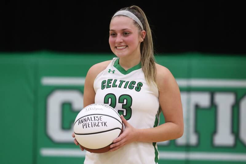 Providence’s Annalise Pietrzyk poses with a commemorative ball marking her 1,000th career points during the game against Minooka in the WJOL Basketball Tournament on Wednesday.