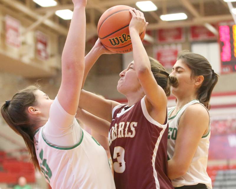 Morris's Olivia Cameron (center) runs into the lane where she is met by Geneseo's Carolanne Greene and Addison Snodgrass during the Class 3A Regional basketball game on Tuesday, Feb. 14, 2023 at Ottawa High School.