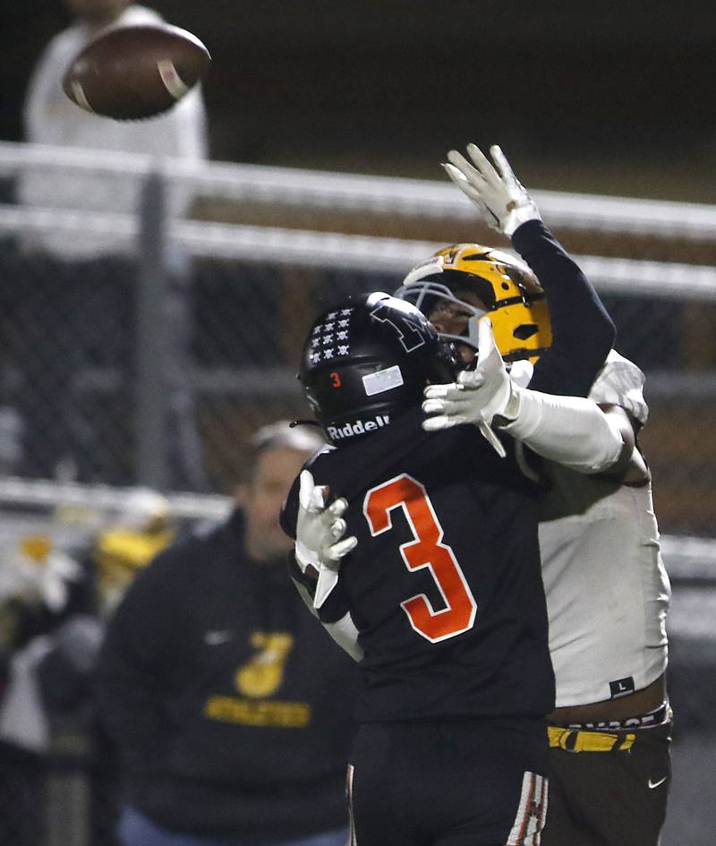 Jacobs' PJ tries to catch the football as he is hit by McHenry's Rogelio Rios during a Fox Valley Conference football game on Friday, Oct. 18, 2024, at McCracken Field in McHenry.