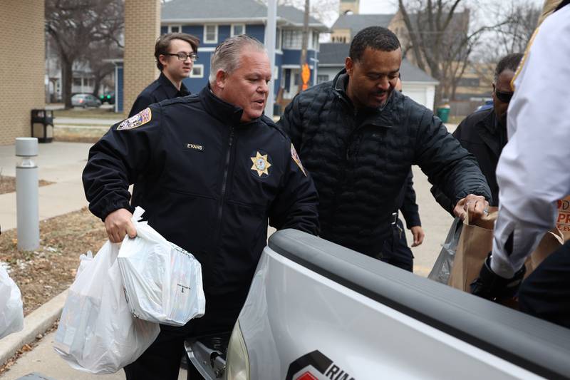 Joliet Police Chief Bob Evans and Deputy Richard Brown unload food donations from the police department’s “Pack the Paddy Wagon” food drive at the Salvation Army in Joliet.