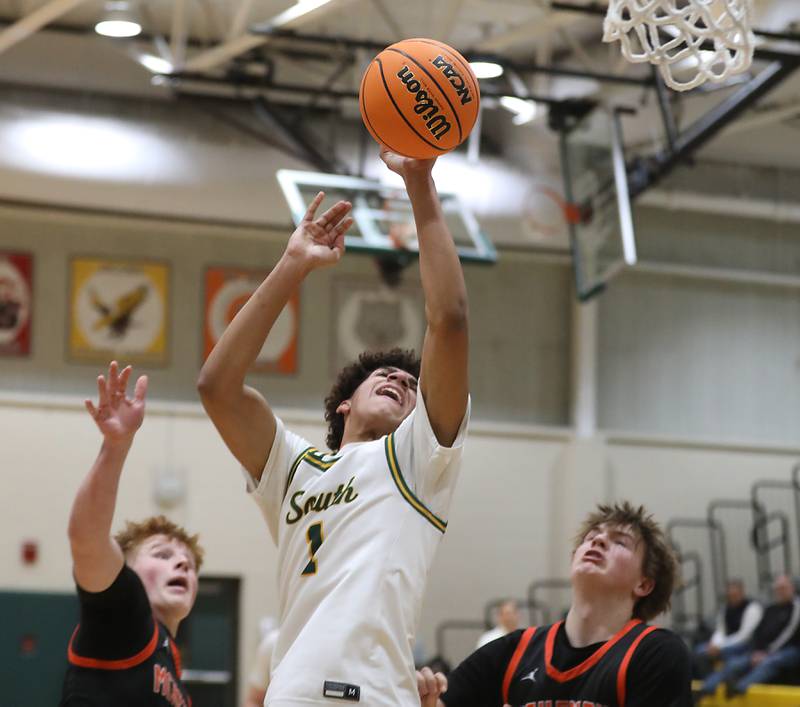 Crystal Lake South's Noah Cook shoots th ball between McHenry's Charlie Schuldt (left) and Nate Ottaway (right) during a Fox Valley Conference boys basketball game on Wednesday, Jan. 14, 2026, at Crystal Lake South High School.