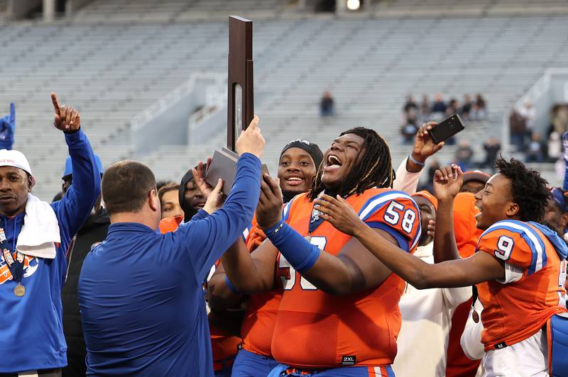 East St. Louis captains accept the trophy after their IHSA Class 6A state championship win over Prairie Ridge Saturday, Nov. 26, 2022, in Memorial Stadium at the University of Illinois in Champaign.