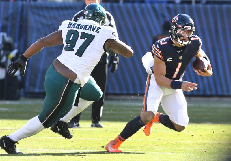 Chicago Bears quarterback Justin Fields scrambles away from Philadelphia Eagles defensive tackle Javon Hargrave during their game Sunday, Dec. 18, 2022, at Soldier Field in Chicago.