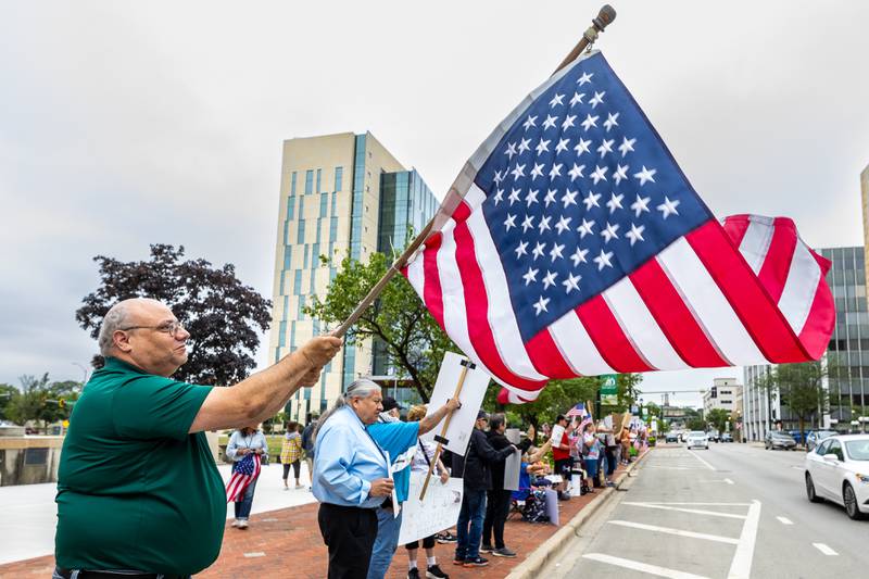 Anthony Domenico waves an American flag during the Good Trouble Lives On event in Downtown Joliet on July 17, 2025.