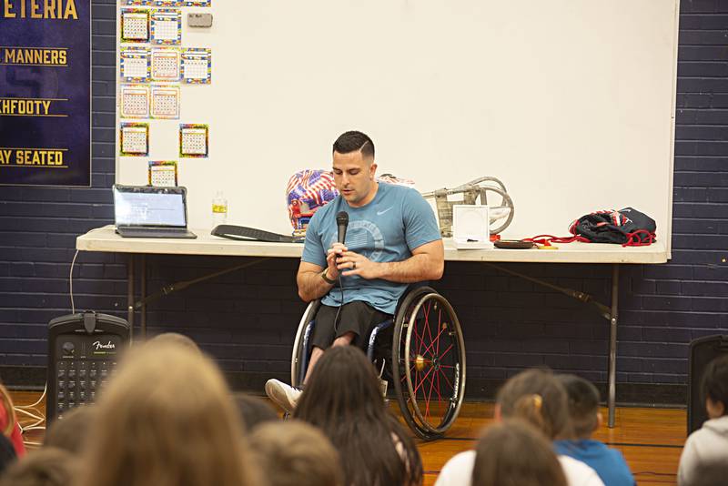 Three-time Paralympic gold medal winning sled hockey player Kevin McKee speaks to a group of Washington School fifth graders Thursday about his life. McKee was born without the lower part of his spine so has been in a wheelchair all his life. He discovered sled hockey at age 15 and made the USA men’s team at 20.