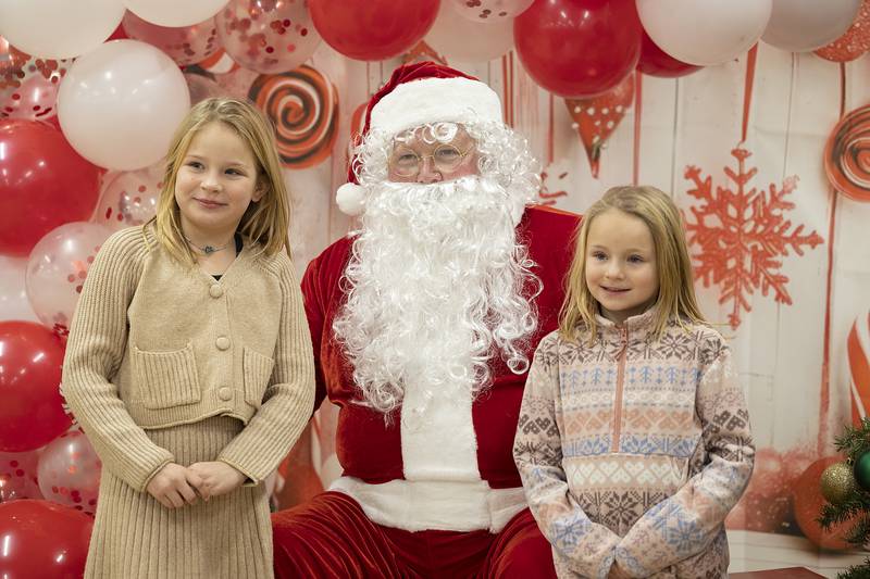 Payton (left), 8, and Kinsley Haring, 6, pose with Santa Wednesday, Dec. 11, 2024, at the senior center in Sterling.