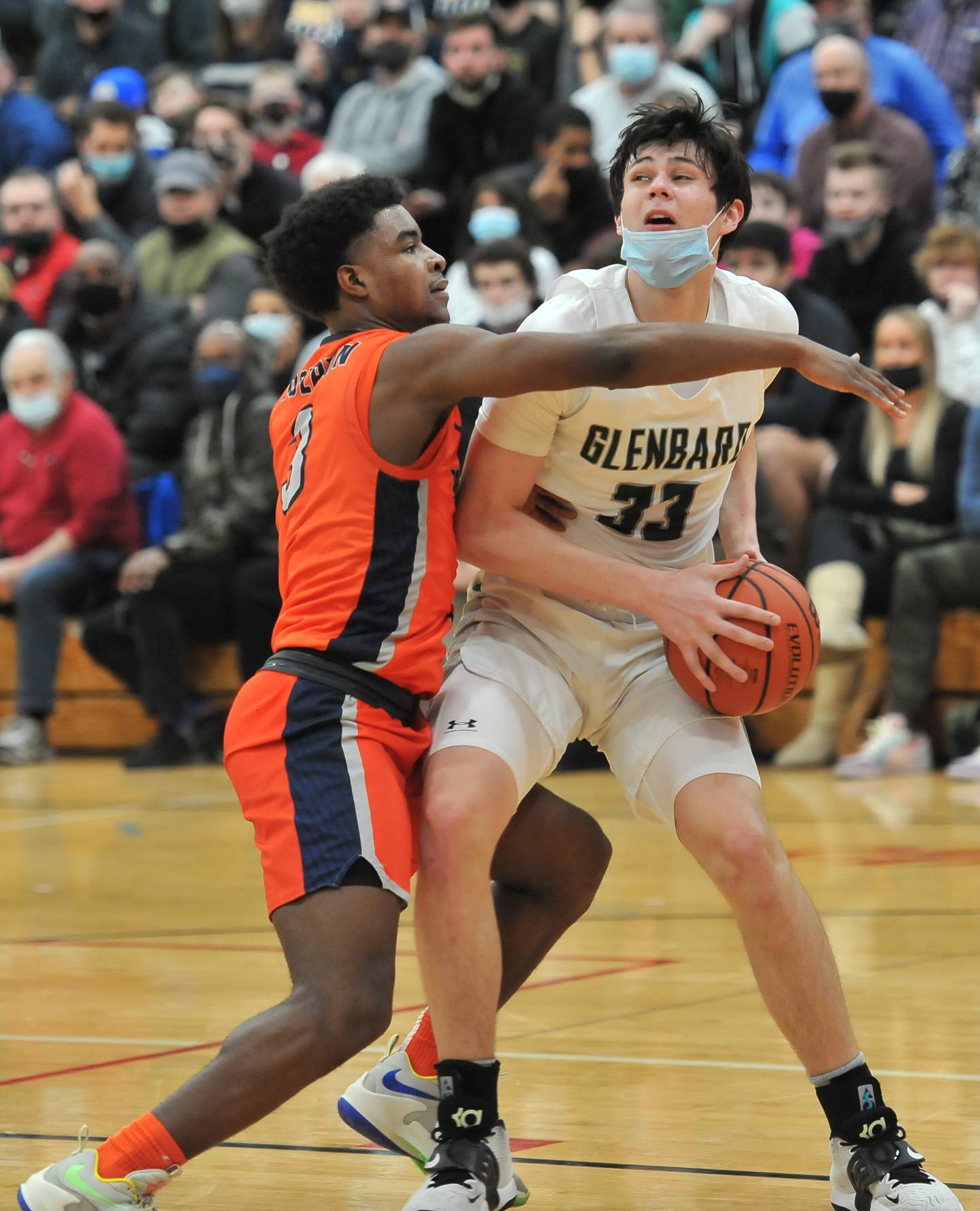 Glenbard West's Bobby Durkin (33) moves to the basket while tightly guarded by Whitney Young's Dalen Davis during a game on Jan. 22, 2022 at Benet Academy in Lisle.