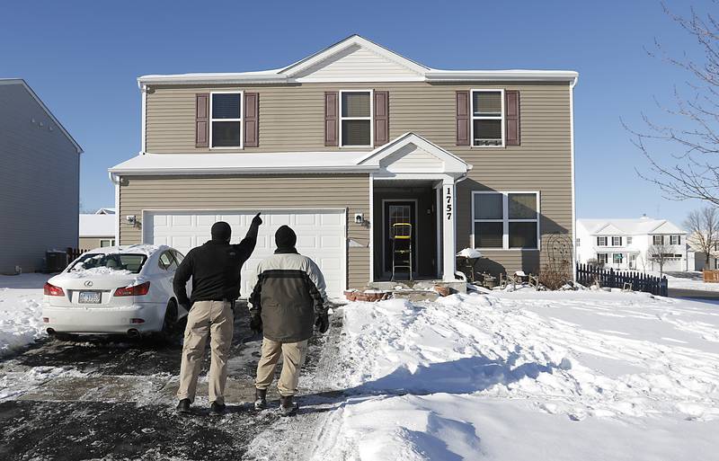 Woodstock police officers look for evidence the morning of Tuesday, Jan. 25, 2022, after a shooting Monday evening, outside a home in the 1700 block of Yasgur Drive in Woodstock.