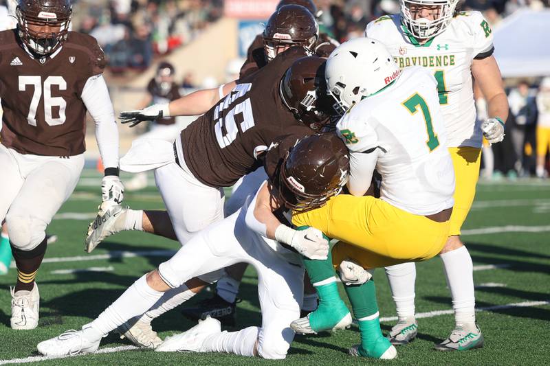 Joliet Catholic’s Nick Bueno, 45, and Griffin Alessio take down Providence’s Jamari Tribett in the Class 5A semifinal on Saturday, Nov. 18, 2023, in Joliet.