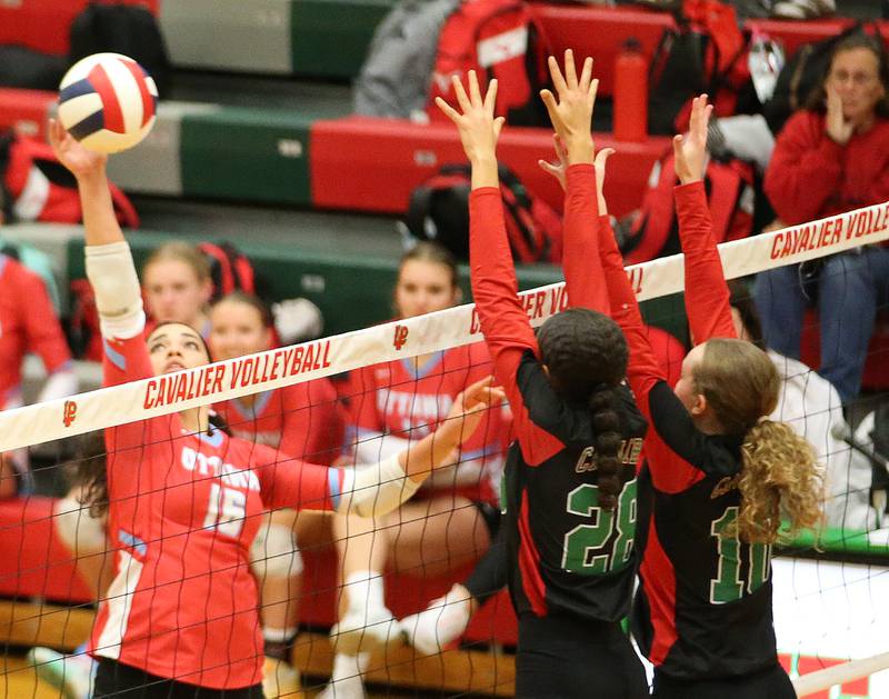 Ottawa's Chey Joachim (16) spikes the ball past La Salle-Peru's Ava Currie (28) and Katie Sowers (10) on Tuesday, Oct. 17, 2023, at Sellett Gymnasium.