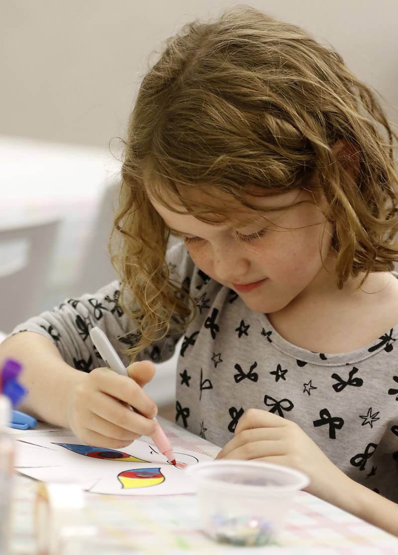 Nora Patnaude, 7, colors her mask as children make masks on Wednesday, Oct. 23, 2024, during at Kids Crafternoon at the Harvard Diggins Library. Children were able to chose between several Halloween themed masks to make.