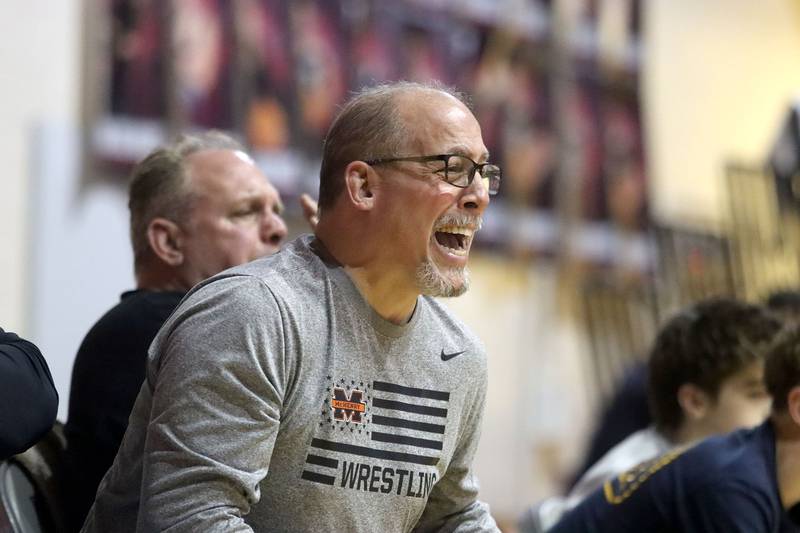 McHenry’s Head Coach Dan Rohman encourages Elian Enciso in a battle with Prairie Ridge’s Jacob Meade at 165 pounds in varsity boys wrestling on Thursday, Jan. 8, 2026 at Prairie Ridge High School in Crystal Lake.
