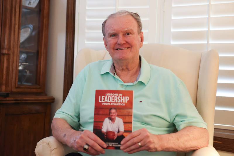 Pat Sullivan, retired St. Francis basketball coach, holds one of his latest books at his home in Shorewood on Thursday, Oct. 10, 2024.