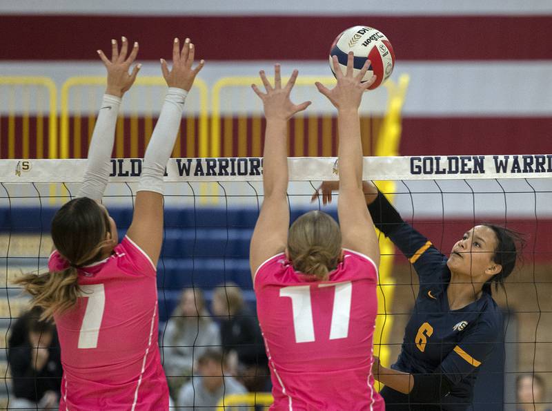 Sterling’s Alasia Harris Rascon spikes against United Township’s Emily Stevens (left) and Tiana Ludin Tuesday, Oct. 15, 2024, in Sterling.