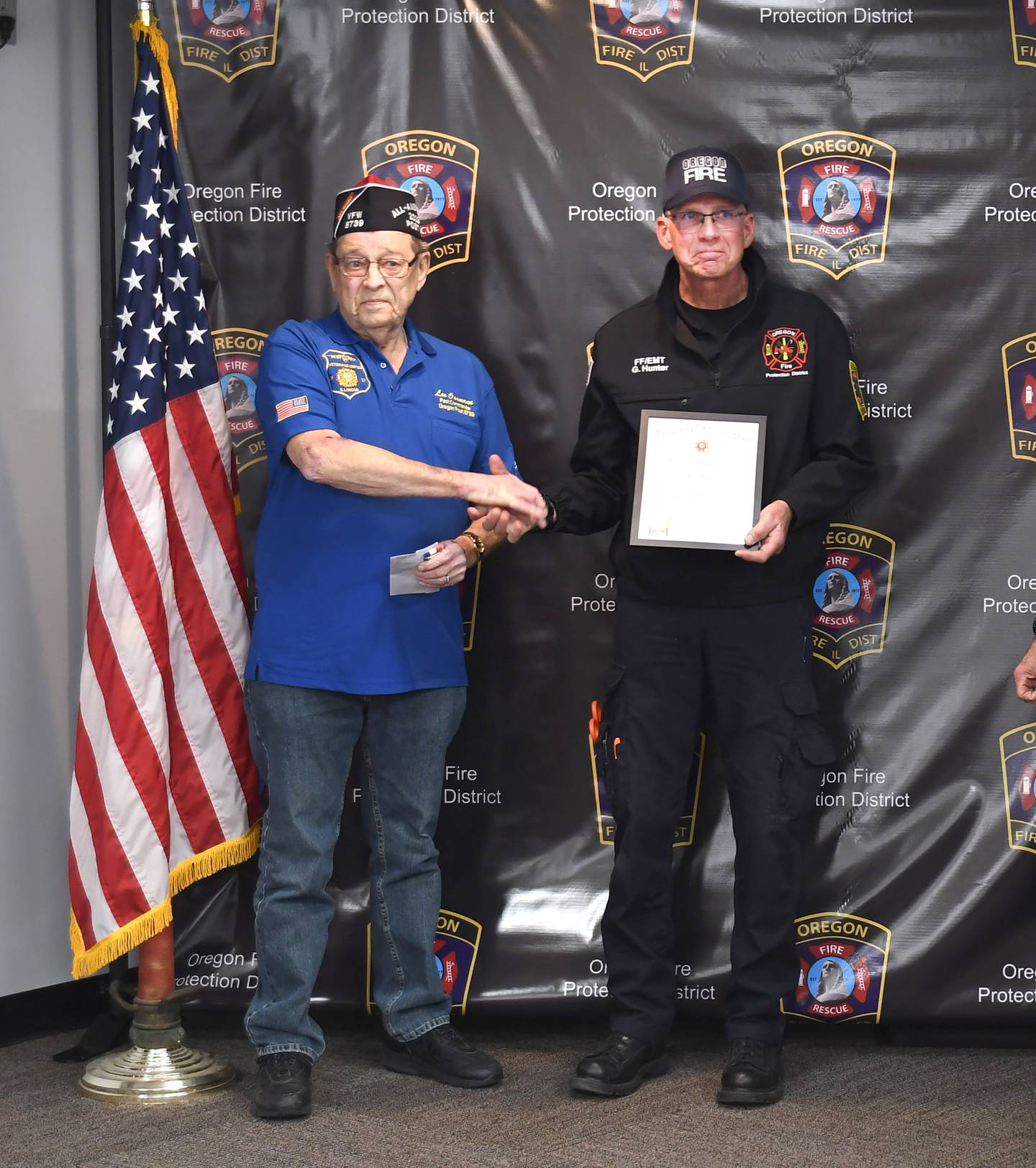 Senior Oregon VFW Vice Commander Lee Ossmann presents Oregon Firefighter/EMT Greg Hunter with the EMT of the Year Award during a presentation at the Oregon VFW Post #8739 on Monday, March 3, 2025.