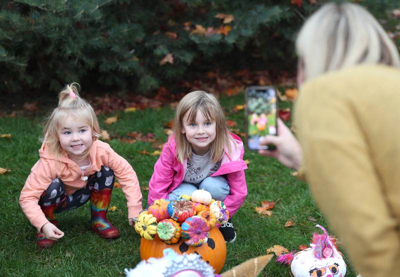 Katherine McLaughlin, from DeKalb, takes a picture of her daughters Josie,  (left) 3, and Nora, 5, with their entry in the pumpkin contest Wednesday, Oct. 25, 2023, during the Sycamore Pumpkin Festival pumpkin check-in on the lawn of the DeKalb County Courthouse in Sycamore.