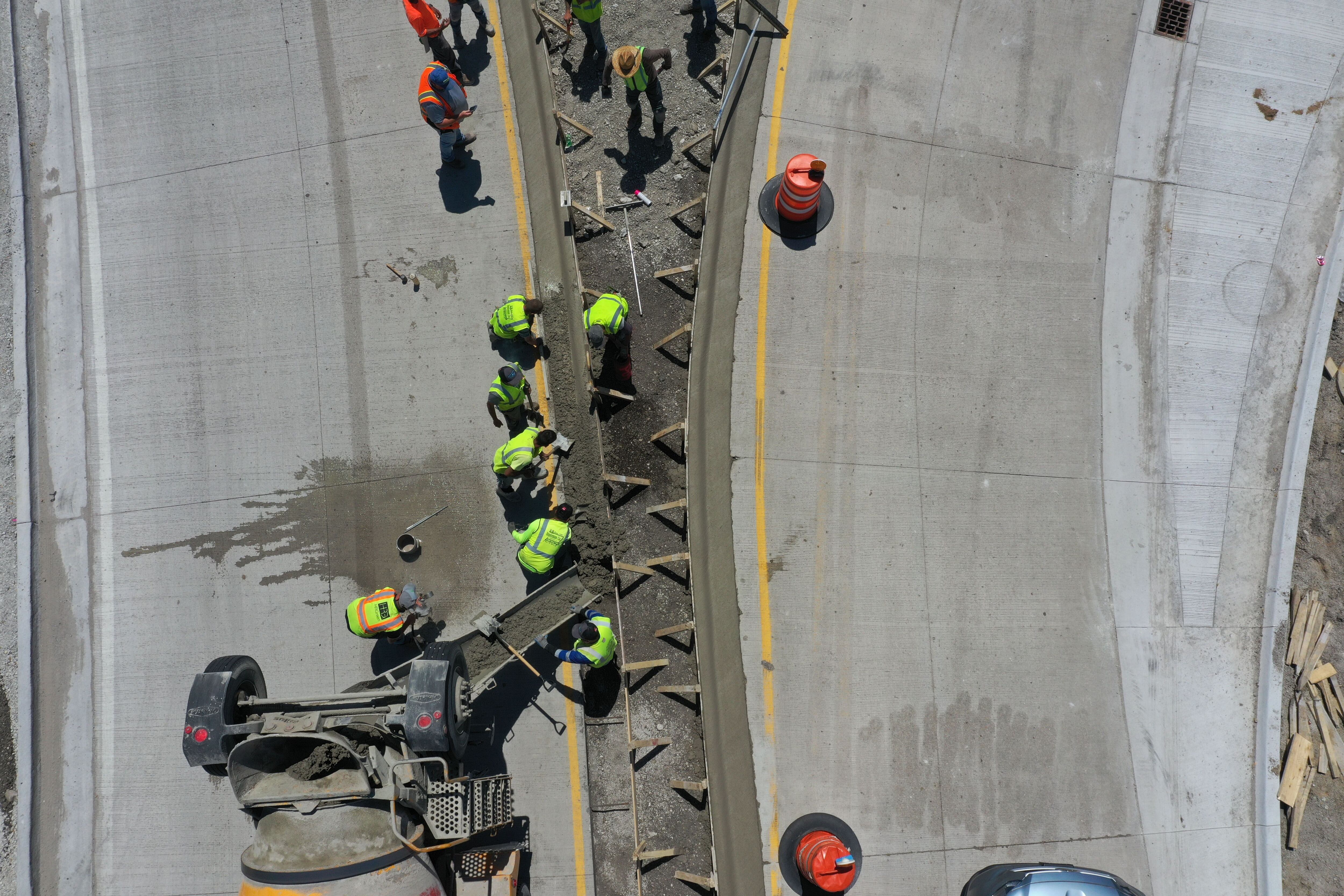 Crews pour concrete on the northern approach to the roundabout on Tuesday, May 16, 2023, at the intersection of Route 178 and U.S. 6 in Utica.
