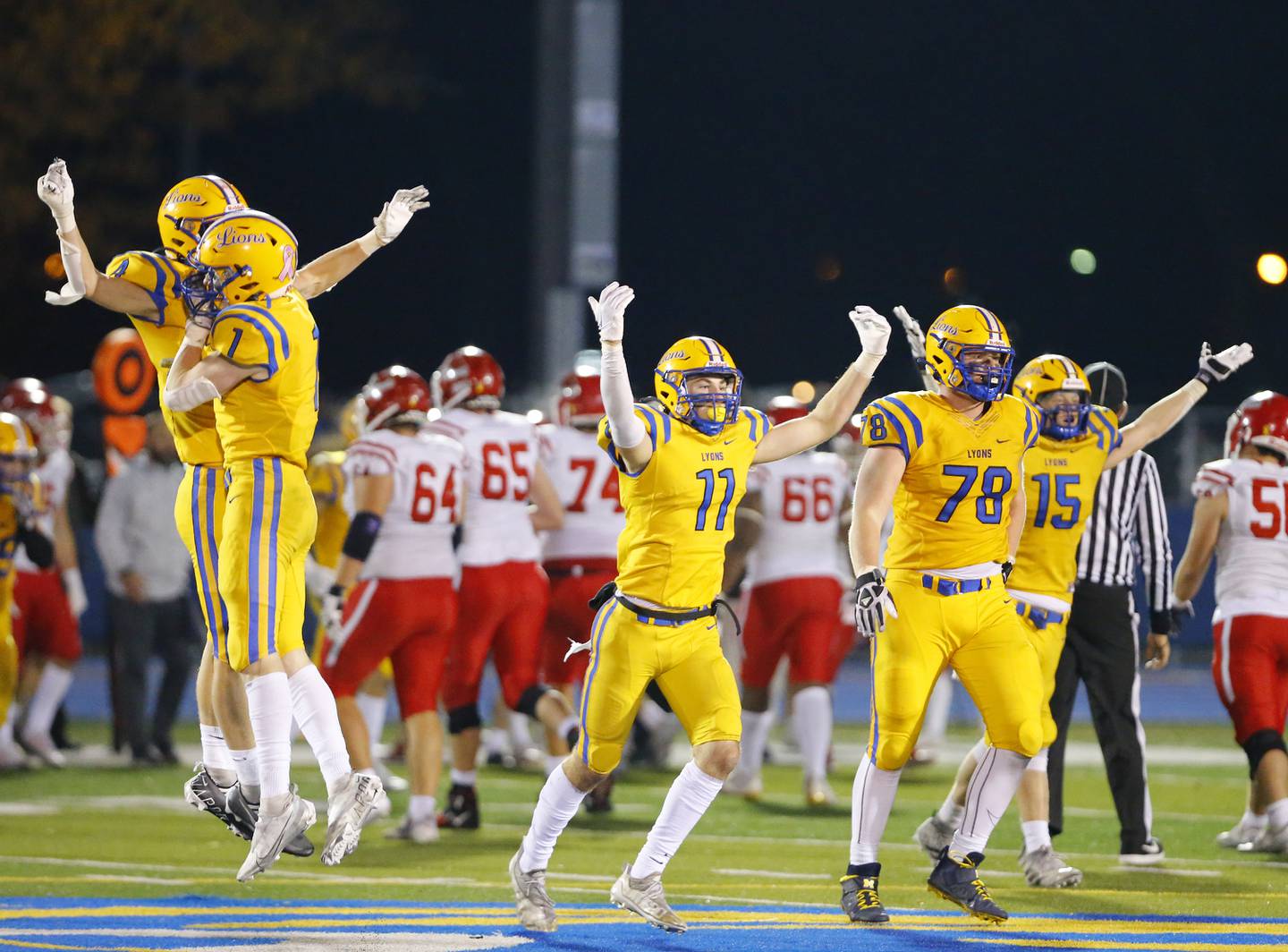 Lyons' defensive line celebrates a fourth down stop during a first round Class 8A varsity football playoff game between Lyons Township and Naperville Central on Friday, Oct. 28, 2022 in Western Springs, IL.