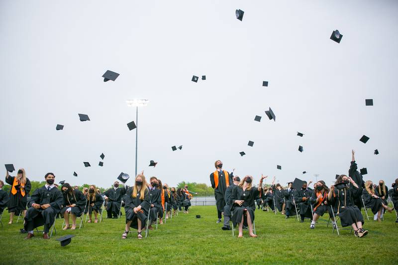 Graduates toss their caps in the air at the conclusion of the 6 p.m. Commencement Ceremony of the Crystal Lake Central Class of 2021 at Crystal Lake Central High School Football Stadium on Sunday, May 16, 2021, in Crystal Lake, Ill.