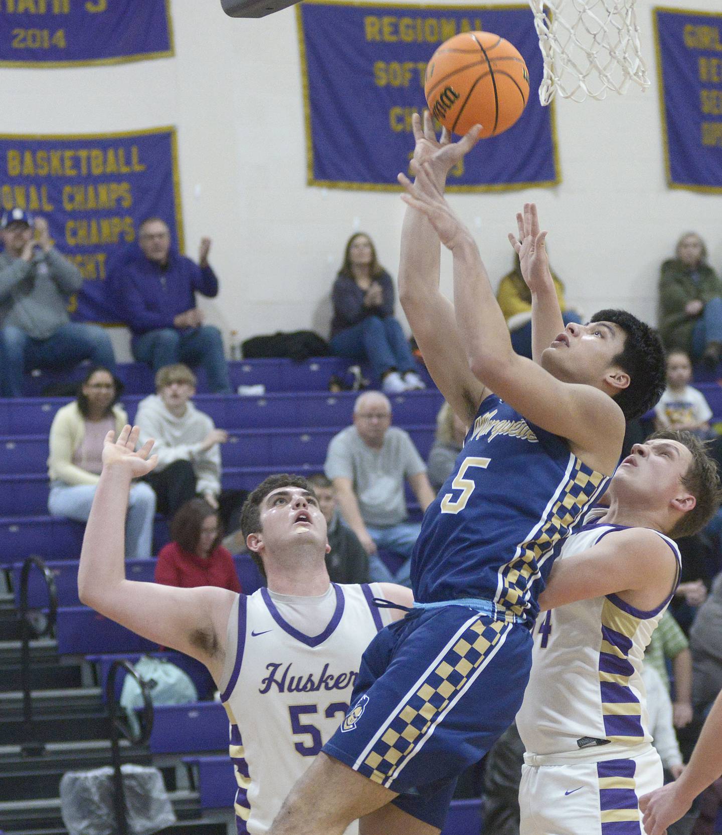 Marquette’s Brayden Cassel  (5) gets between Serena’s Hendrix Johnson and Nolan Muffler for a field-goal try Tuesday, Feb. 11, 2025, in Serena.