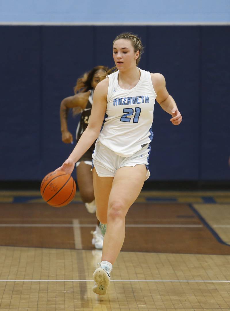 Nazareth's Olivia Austin (21) brings the ball up court during the girls varsity basketball game between Carmel High School and Nazareth Academy on Wednesday, Dec. 7, 2022 in LaGrange, IL.