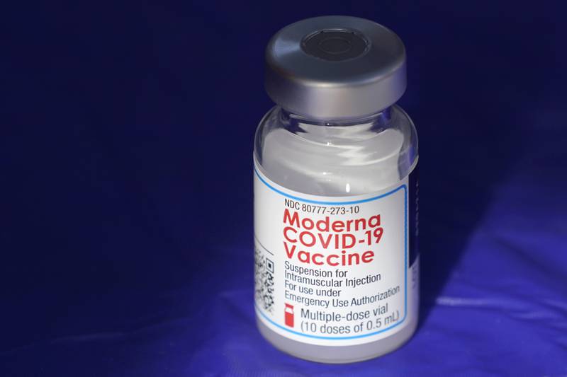FILE - In this March 4, 2021 file photo, a vial of the Moderna COVID-19 vaccine rests on a table at a drive-up mass vaccination site in Puyallup, Wash., south of Seattle.  Moderna’s COVID-19 vaccine brought in nearly $7 billion in the final quarter of 2021, and the drugmaker says it has signed purchase agreements for another $19 billion in sales this year.