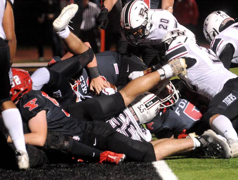 Yorkville quarterback Michael Dopart (middle) scores the Foxes first touchdown through a pile of Plainfield North defenders during a varsity football game at Yorkville High School on Friday, Oct. 20, 2023.