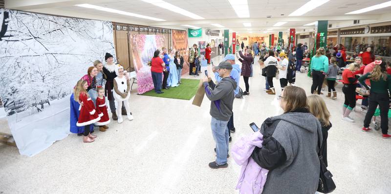 Kids pose with L-P School students characters dressed up as Disney characters during the Santa's Workshop on Saturday, Dec. 3, 2022 at La Salle-Peru Township High School.