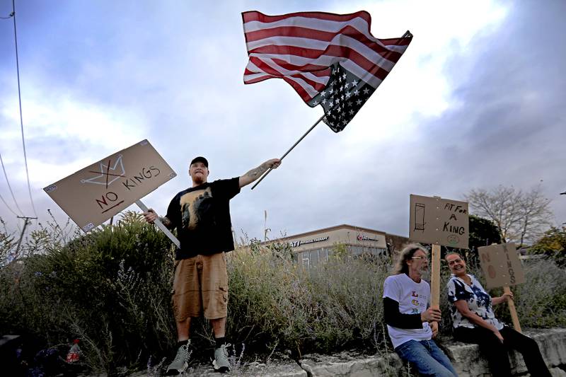 William Sicca of McHenry waves the upside down American Flag as a symbol of distress during a "No Kings” protest rally on Saturday, Oct. 18, 2025, along Route 31 in McHenry. The protest drew thousands of protesters to the area to protest the policies of President Donald Trump.
