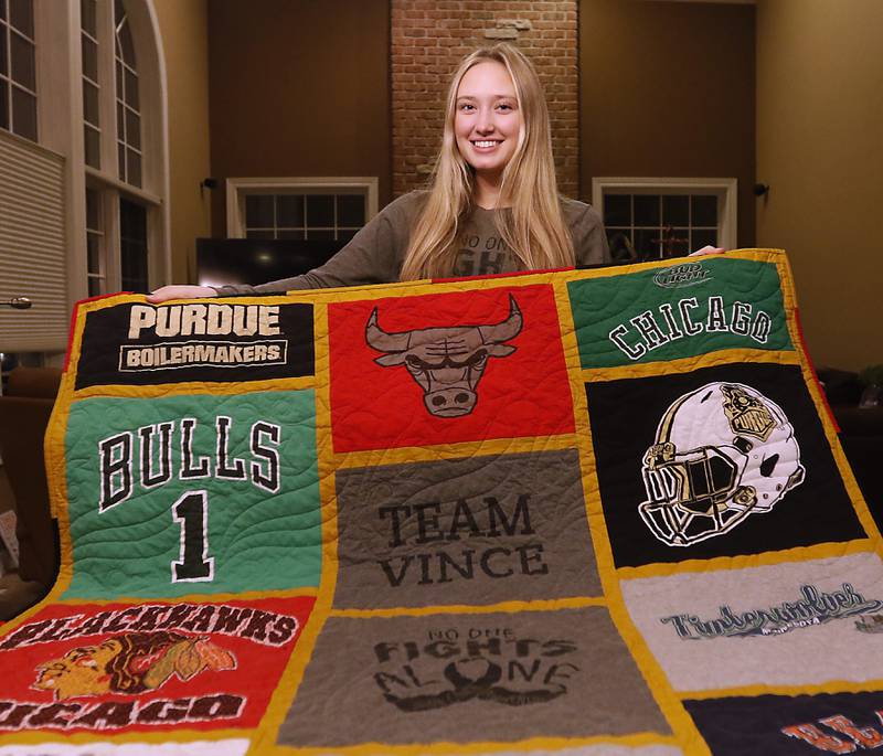 Gabi DeGiulio, who lost her father, Vince, in 2019, with a quilt made out of his old T-shirts. She is a member of the One Million Monarchs, an organization that helps teenagers grieve the loss of a loved one. The Crystal Lake organization has received a grant that will help them expand the program, add more members and include more retreats.