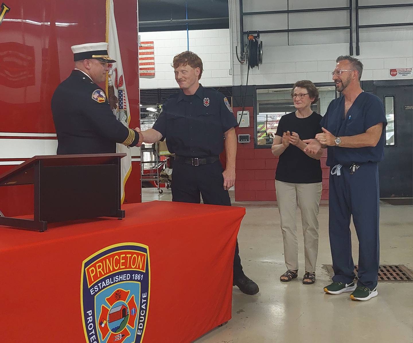 New full-time Princeton firefighter and EMT Daniel Crowe is congratulated by Fire Chief Scott Etheridge following his oath as his parents Mary Beth and Dr. Kurt applaud Monday, May 20, 2024, at the Princeton Fire Department.