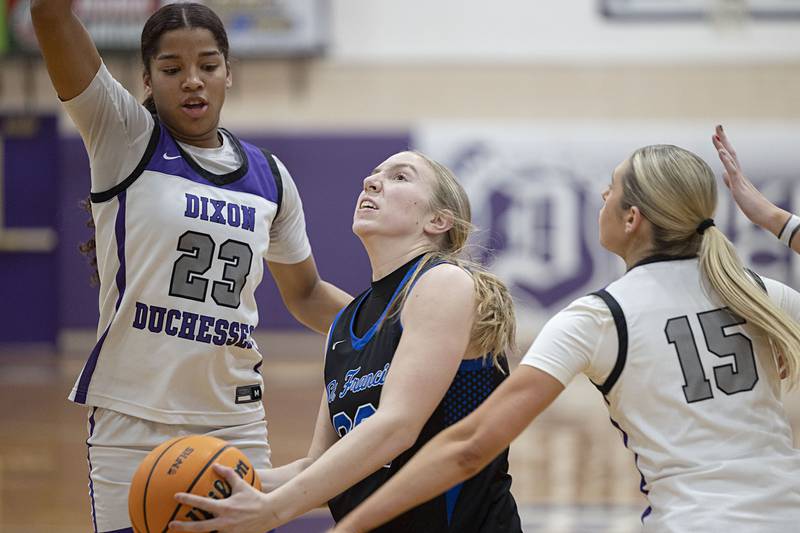 St. Francis’ Tenley Glock drives to the hoop against Dixon’s Ahmyrie McGowan (left) and Morgan Hargrave Saturday, Jan. 10, 2026.