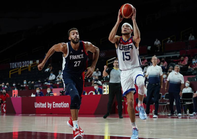 United States' Devin Booker (15) drives to the basket ahead of France's Rudy Gobert (27) during men's basketball gold medal game at the 2020 Summer Olympics, Saturday, Aug. 7, 2021, in Saitama, Japan.