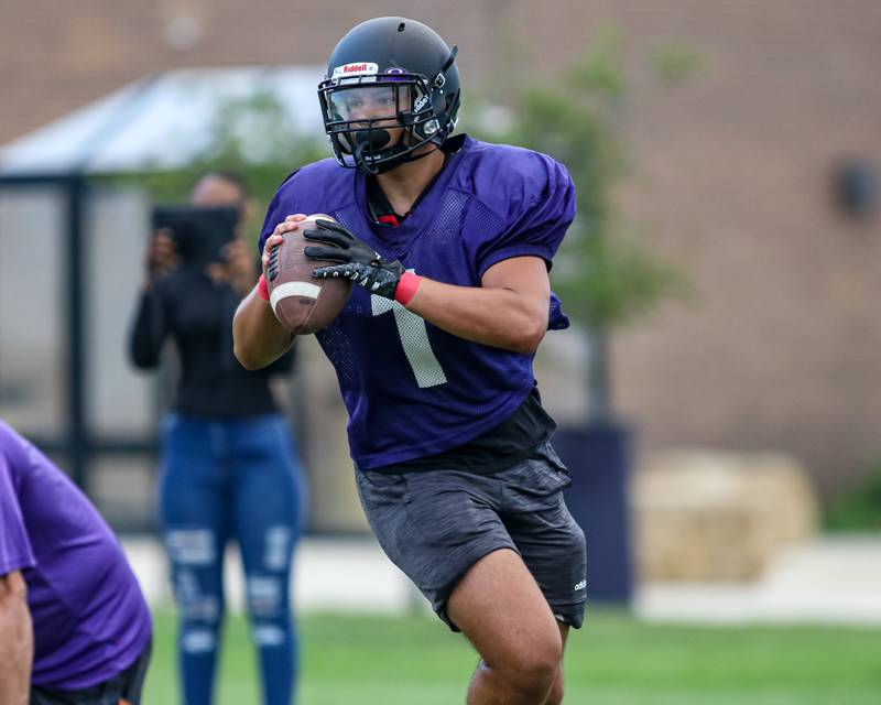 Armando Martinez looks for a receiver while rolling out at Plano High School football practice.  August 9, 2023.