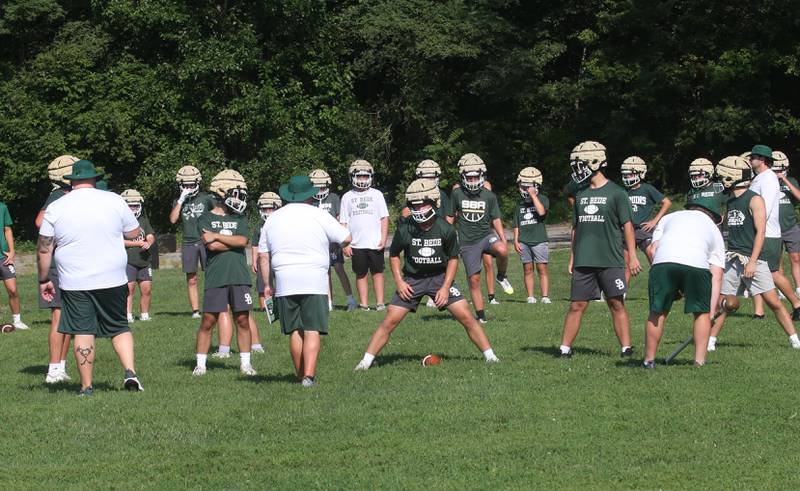 Members of the St. Bede football team run a play during the first day of football practice on Monday, Aug. 11, 2025 at St. Bede Academy.