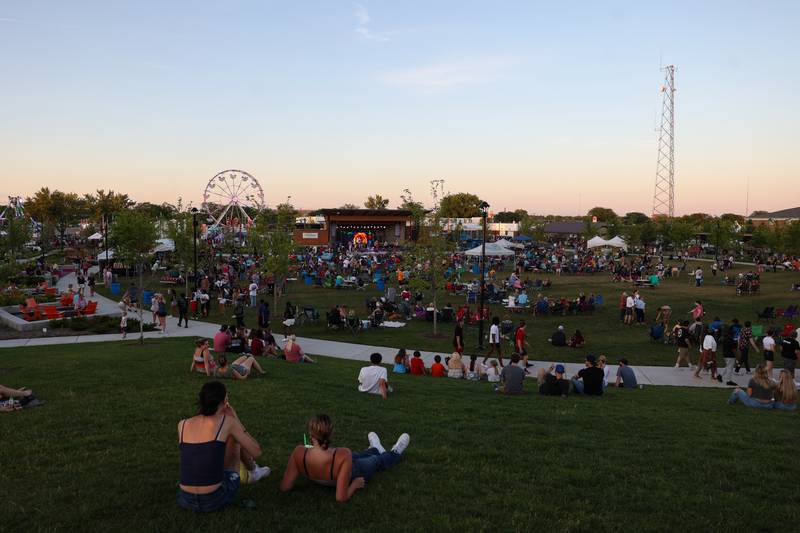 Attendees lounge on the hill as live music is performed during the 50th Bourbonnais Friendship Festival at The Grove on Saturday, June 28, 2025.