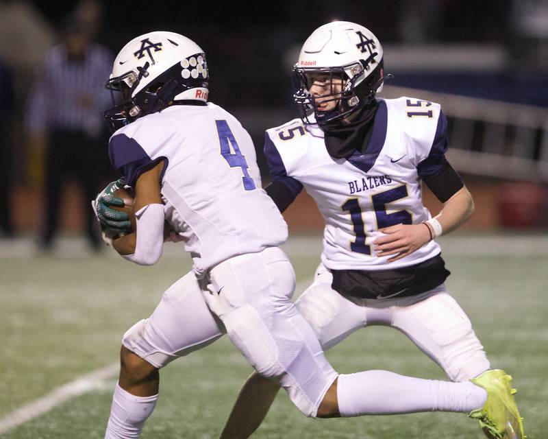 Addison Trails Nico Dill hands the ball off to Damari Jones against Downers Grove South on Friday, Oct.20,2023 in Downers Grove.