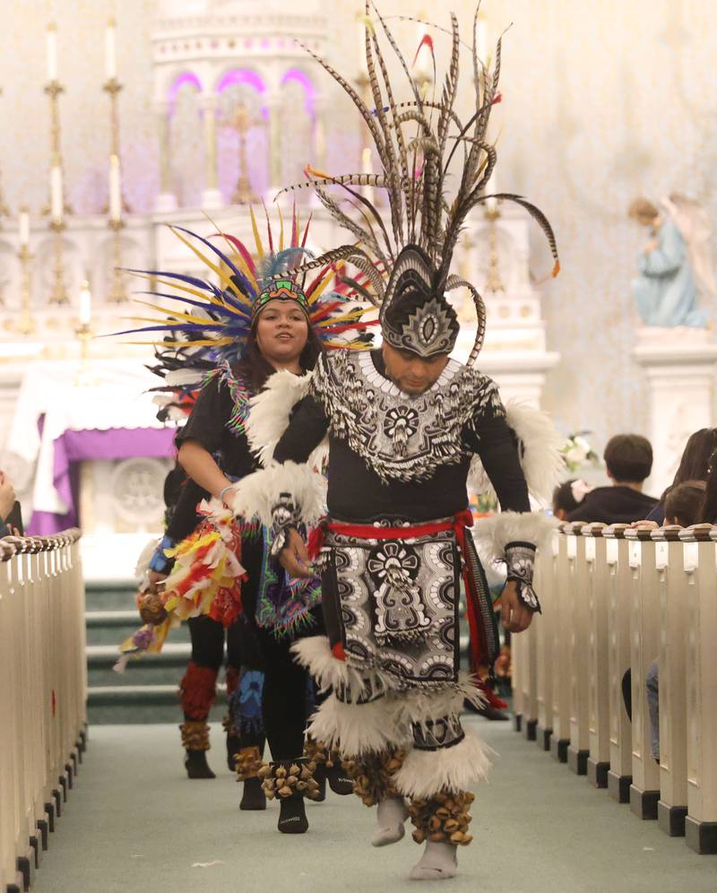 Dancers perform down the main isle at St. Patrick's Catholic Church during the Lady of Guadalupe vigil Chichimeca dance on Thursday, Dec. 12, 2025 in La Salle. The Chichimeca dance is a vibrant, Indigenous-rooted devotional tradition where dancers (Danzantes) perform to honor the Virgin Mary's appearance to Juan Diego in 1531, symbolizing faith, hope, and cultural fusion, often involving elaborate costumes, feathers, and drumming, leading up to the main Feast Day on December 12th, with celebrations happening globally in parishes.