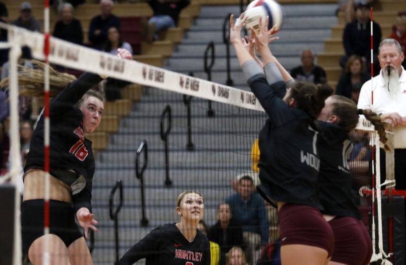 Huntley's Georgia Watson (left) hits the ball through the block of Prairie Ridge's Maizy Agnello (center) and Adeline Grider (right) during a Fox Valley Conference volleyball match on Tuesday, Oct. 8, 2024, at Huntley High School.