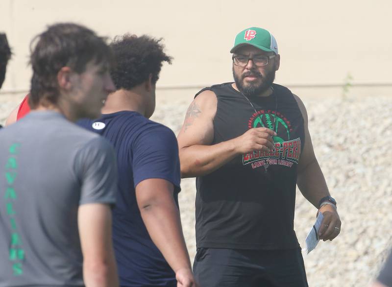 L-P football head coach Jose Medina talks to his team at Howard Fellows Stadium during their football camp on Tuesday, July 25, 2023 in Peru.