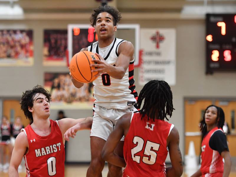 Benet’s Blake Fagbemi (0) goes high over the Marist defense for a basket during a game on Friday, Dec. 13, 2024 at Benet Academy in Lisle.