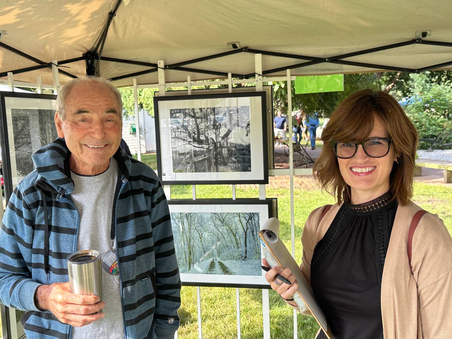 Local artist Charlie Kerr, who died in January 2025, stands with event judge Jessica Monica next to artwork at an art festival in Grand Detour.