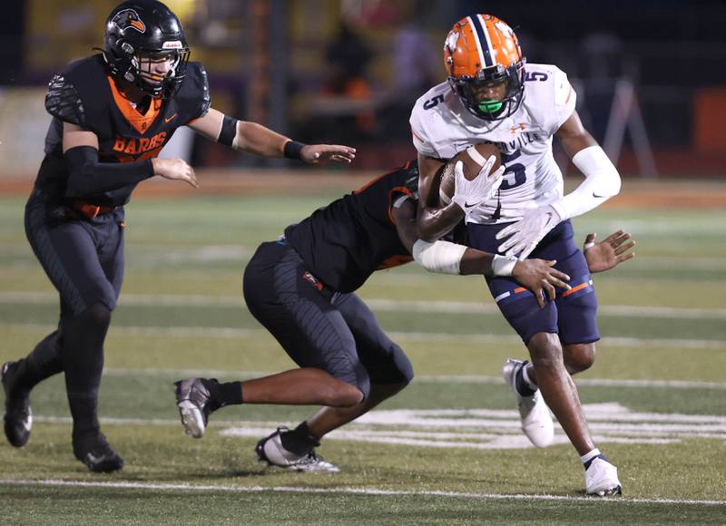 Naperville North's Luke Williams tries to break a DeKalb tackle during their game Friday, Sept. 22, 2023, at DeKalb High School.