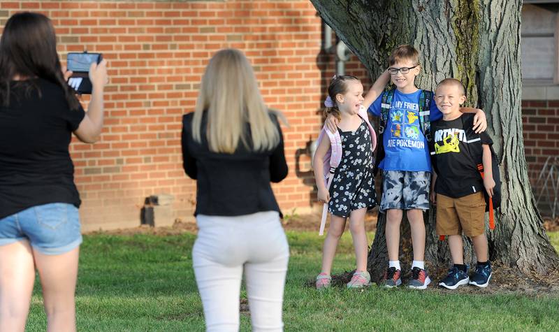 First-grader Savannah Buschman, her brother Cooper, 3rd grade and their cousin Ryan Hansen, 1st grade have their picture taken by their moms on the first day of school at Haskin Elementary in Sandwich on Wednesday, Aug. 17, 2023.