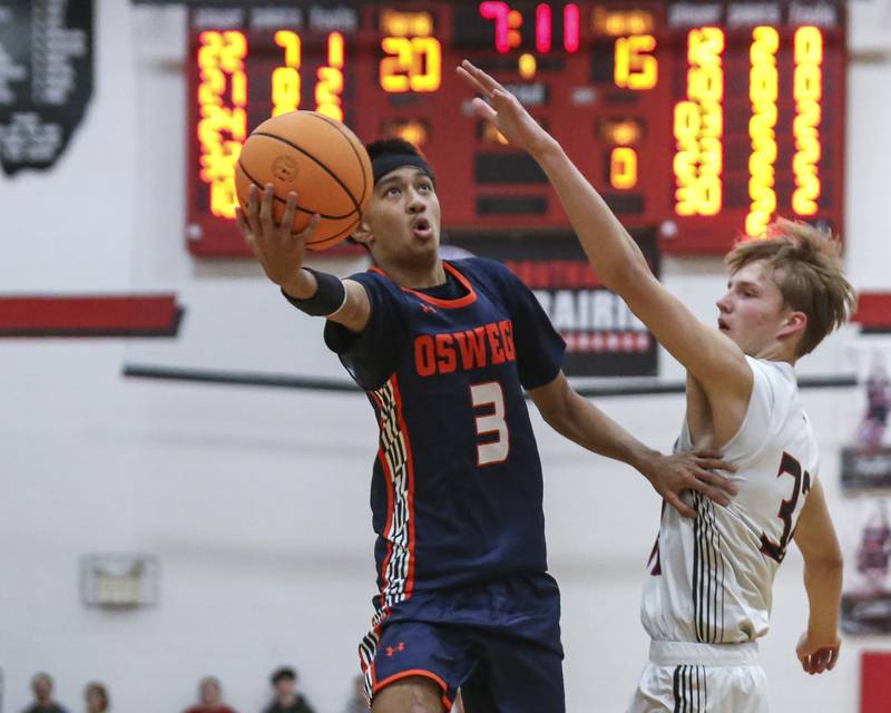 Oswego's Ethan Vahl (3) puts up a half hook shot over Yorkville's Joey Jakstys (32) during their basketball game between Oswego at Yorkville Friday, Dec 12, 2025 in Yorkville.