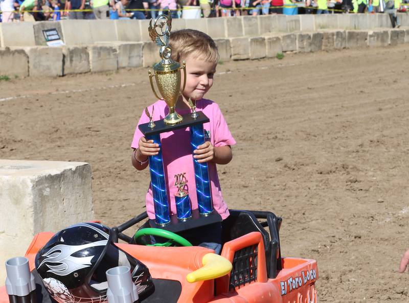 Khyler Cade of Bradford, holds his second place trophy after racing in the Power Wheels Kids Demo Derby during the 170th annual Bureau County Fair on Saturday, Aug. 23, 2025 in Princeton.