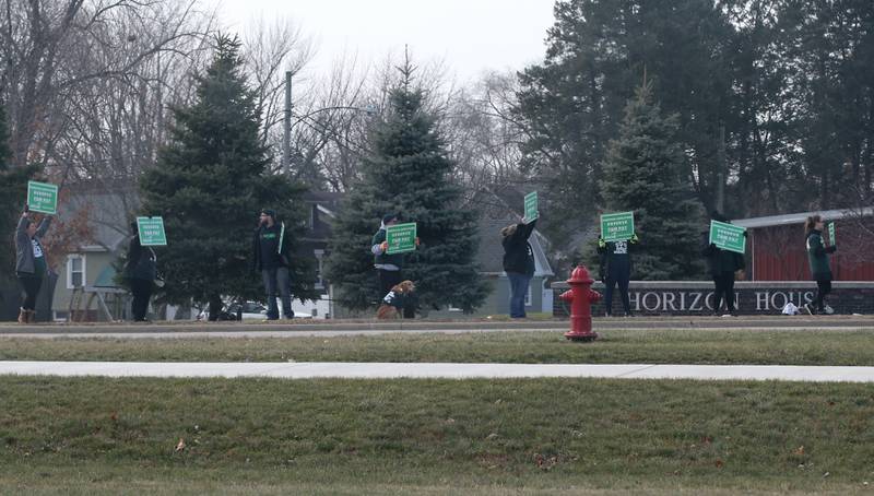 Horizon House employees hold signs reading "deserve better pay" outside of the Horizon House on Thursday, Dec. 8, 2022 in Peru.